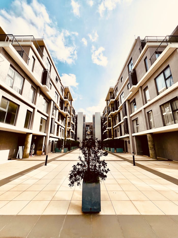 Symmetrical view of a modern apartment complex under a bright blue sky.